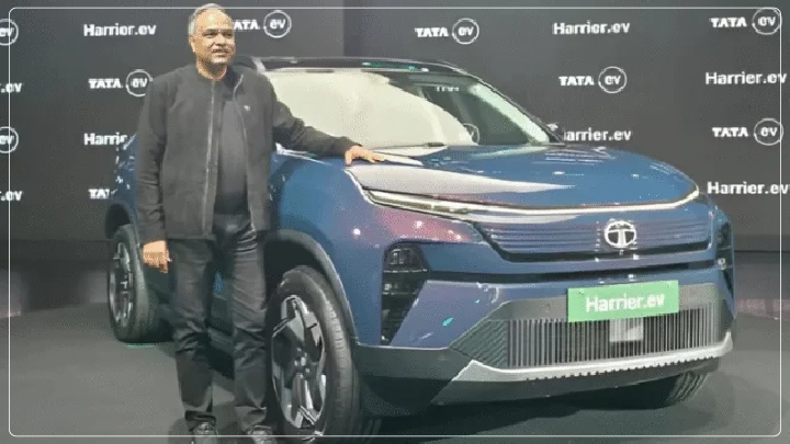 Man posing with Tata Harrier.ev electric SUV at showcase event